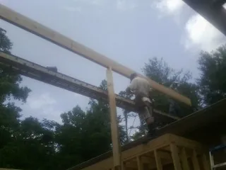 Carpenter setting a ridge beam over a new addition frame — Ice Dam Removal by Roofing Brothers in Opolis