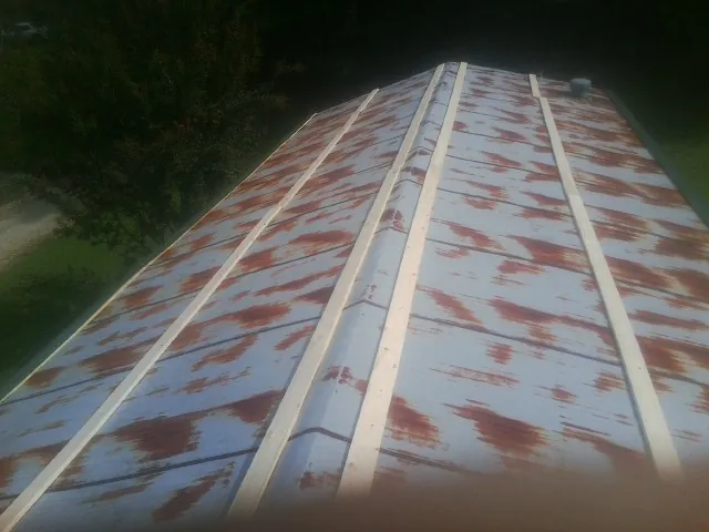 Rusted metal roof panels with new wood purlins before replacement — Storm Damage Roof Repair in Opolis by Roofing Brothers