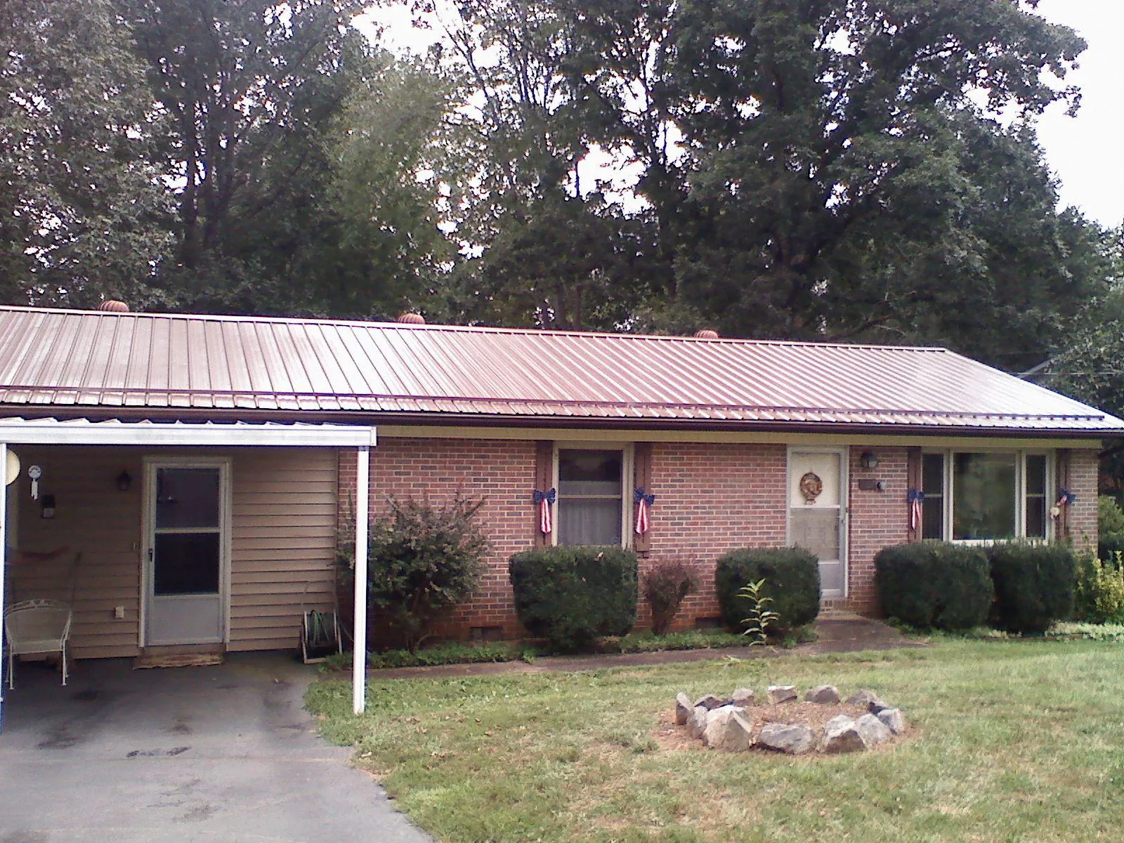 Bronze metal roof and carport on a brick ranch home — Roof Repair work by our crew in Opolis