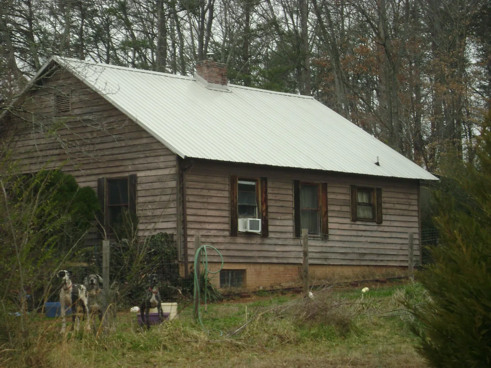 White metal roof on an old wood sided farmhouse, from a Metal Roof Installation job in Opolis